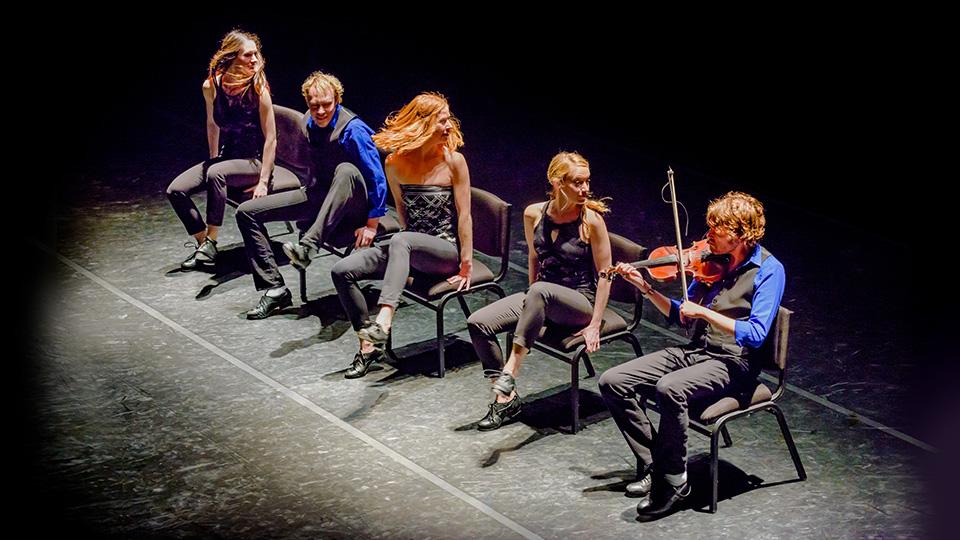 五名StepCrew成员坐在舞台上的椅子上，其中一人正在拉小提琴